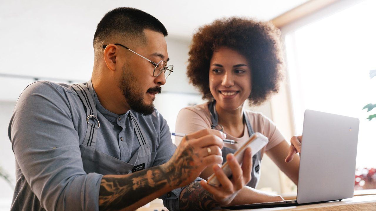 Two people running a business between them, looking at a laptop together